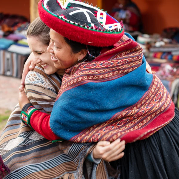 Royal Adventures staff embracing an Andean woman in Cusco